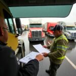 New Entrant Safety Audit Survival Tips shown during a rainy roadside inspection with a truck driver handing documents to a DOT officer